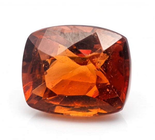A cushion-cut faceted gemstone with a warm amber-orange color and reddish-brown undertones, shown on a plain white background.